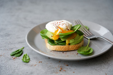Avocado toast with poached egg and spinach. Healthy breakfast concept