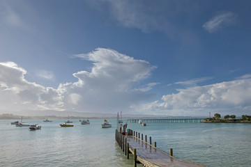 Fototapeta na wymiar Moeraki coast and sea. Boats. New Zealand. Jetty