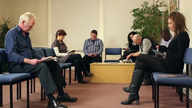 People / Patients sat in Waiting room awaiting Healthcare appointments. Could be a Doctor or dentist surgery clinic. Stock Video Clip Footage. 