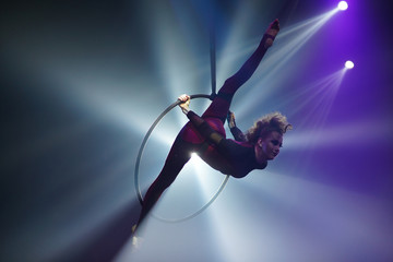 Flexible young woman make performance on aerial hoop, flexiable split on aerial hoop, aerial circus...
