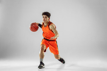 Young basketball player of team wearing sportwear training, practicing in action, motion in run...