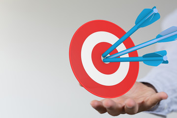 hand holding a target with darts hitting the center over white background. Concept of .
