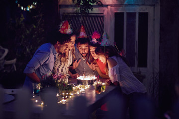 close friends blowing birthday candles together. togetherness, making a wish, close, friends, concept