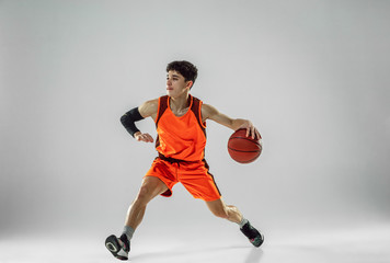 Young basketball player of team wearing sportwear training, practicing in action, motion in run...