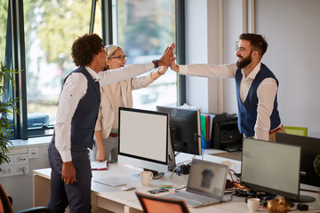 teambuilding moment of three colleagues in open space office. teamwork, success