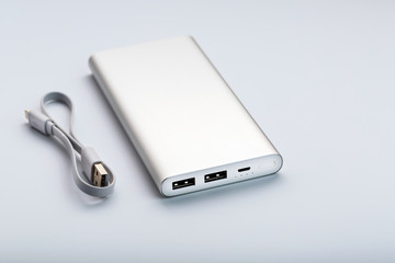 Powerbank for charging mobile devices with cable, on a white background.