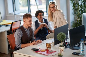 three colleagues watching and analyzing content at computer monitor in office. casual modern business