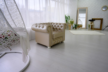 Photo of a white bright interior of a bright room with a stylish sofa on a white floor