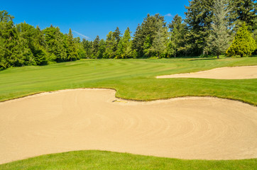Obraz premium Golf course with gorgeous green and sand bunker