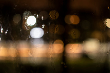 raindrops on the window against the background of the night city