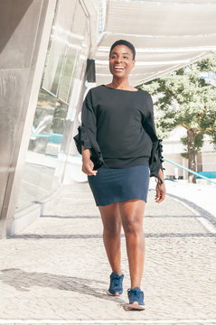 Happy Cheerful Black Woman Seeing Old Friend. Joyful African American Lady Walking Outside, Staring Into Distance, Smiling An Laughing. Way To Meeting Concept