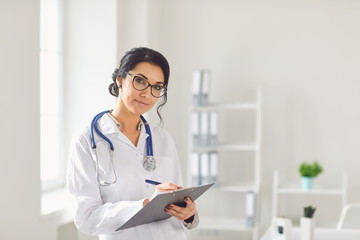 Woman doctor pediatrician standing in the white office of the hospital.