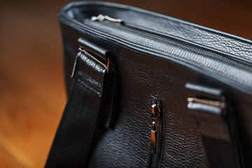 Details and elements of the bag are handmade from black leather, close-up, macro locks.