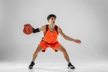Young basketball player of team wearing sportwear training, practicing in action, motion in run...