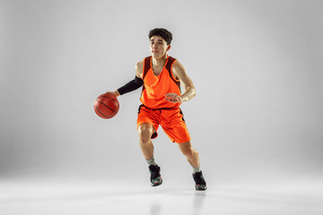 Young basketball player of team wearing sportwear training, practicing in action, motion in run...