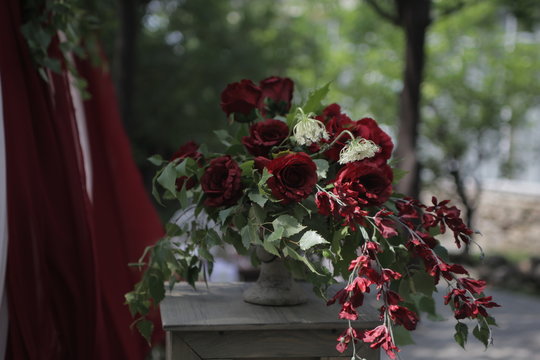 Red Flowers In A Stone Vase On The Table