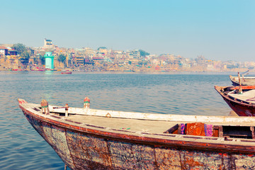 Fototapeta na wymiar Varanasi - traditional fishing boats and view from other side of Ganges River. Uttar Pradesh, India