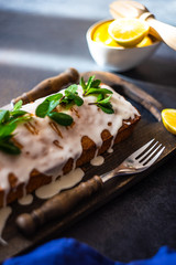 Tasty lemon cake with ingredients on stone background