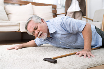 A senior man fell to the ground, He has a headache.