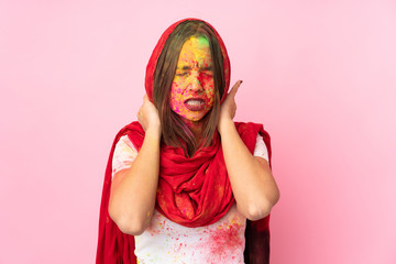 Young Indian woman with colorful holi powders on her face isolated on pink background with neckache