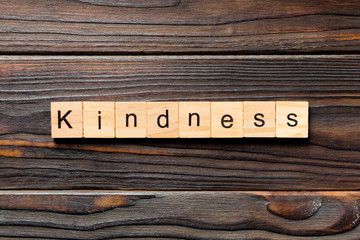 kindness word written on wood block. kindness text on table, concept