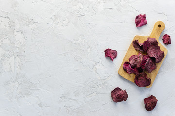 Beetroot chips on a wooden board. Horizontal orientation, copy space, top view.