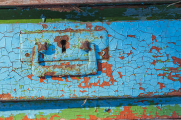 closeup painted wooden board in a crack, outdoor ountryside background