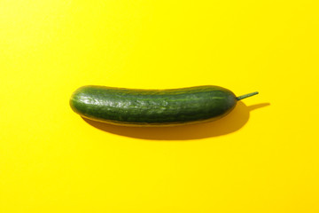 Fresh cucumber on yellow background, space for text