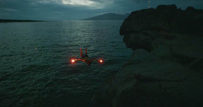 Extreme cliff jumping man backflipping off of an sea cliff with burning red hot flares, epic stuntman moments, people are awesome
