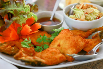 Thai food. Fried fish with fish sauce and side dishes sauce mix in vinegar and sugar with ingredient mango slices, chili, and cashew nuts.