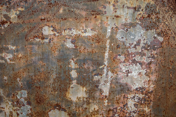 Rusty color rough textured cement concrete  wall with varying shades of gray, brown and cream with peeling layers