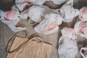 A rag bag surrounded by crumpled used plastic bags. View from above. Grunge style. Copy space