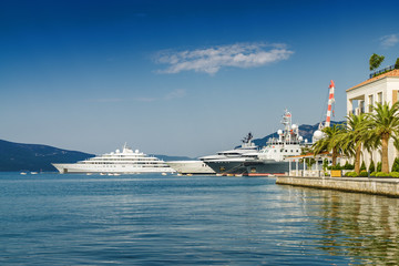 Fototapeta na wymiar Beautiful embankment on the background of luxury yachts at the port of Tivat, Montenegro.