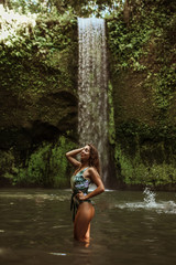 Beautiful sexy girl under a waterfall in Indonesia.