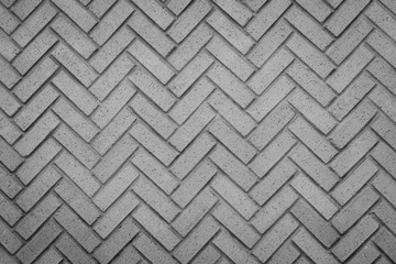 a herringbone pattern brick wall in a neutral gray color