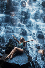 Fototapeta na wymiar Beautiful sexy girl under Kanto Lampo waterfall in Indonesia.