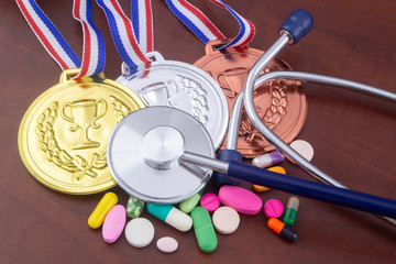 Doping in sport concept. Stethoscope, drugs and medals on table.