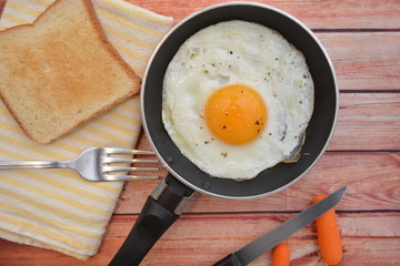 uovo cucinato in padella buon cibo per colazione su sfondo di legno