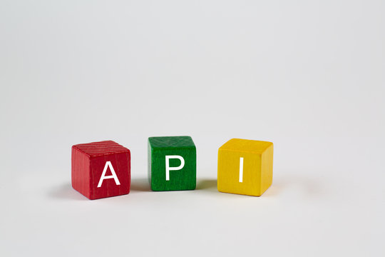 colored blocks against an isolated white background contain the letters API, which stand for Application Programming Interface. Free space is available in this photo.
