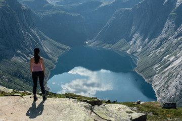 Girl standing near mountain lake, Norway, landscape picturesque view, Ringedalsvatnet lake panorama near Trolltunga