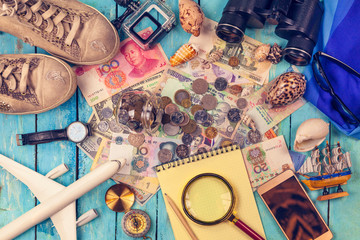 Travel concept background. Overhead view of Traveler's accessories, Essential vacation items, Essential vacation items: sneakers, binoculars,  notepad, watch, phone, glasses, hat, passport, money;