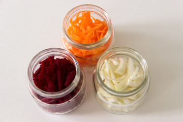 Storage of chopped vegetables in glass jars. White background