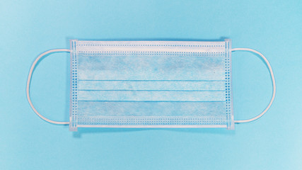 Surgical protective face mask laying on blue background