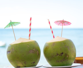 Two green fresh coconuts on the tropical beach.Travel honeymoon concept