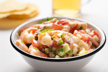 Mexican shrimp ceviche with tomato and serrano pepper on white background