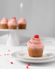 Cupcake with pink buttercream and pomegranate seeds