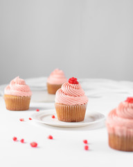 Cupcake with pink buttercream and pomegranate seeds