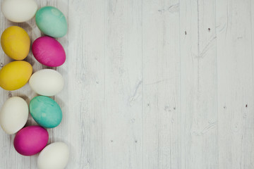 Easter background with colored Easter eggs on wooden grey table. Top view. Copy space
