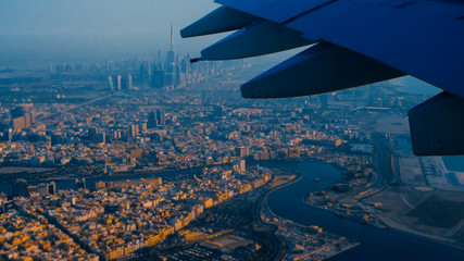 View of Dubai from the airplane window, sunset time and rich colors.