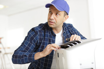 a mature electrician repairing appliance